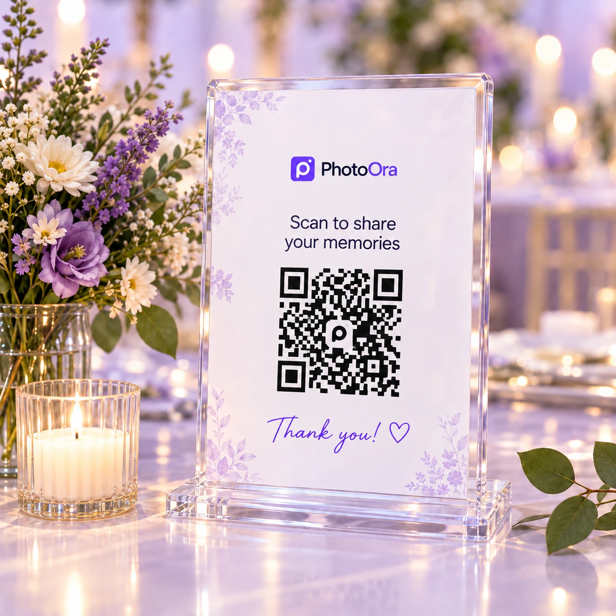 A clear PhotoOra QR sign beside lavender flowers and candlelight